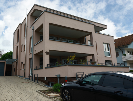 Modernes Mehrfamilienhaus in Konstanz mit Zufahrt und Parkplätzen vor dem Haus.